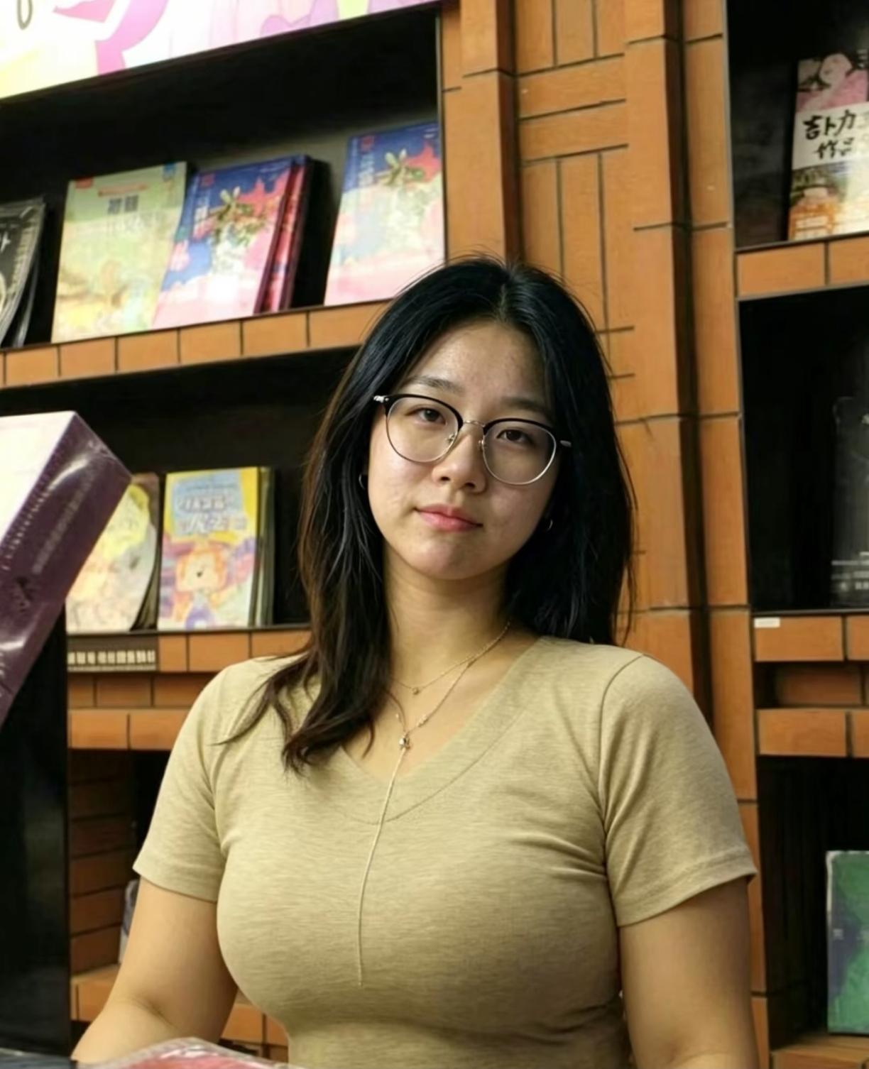 戴眼镜的女孩站在书架前。