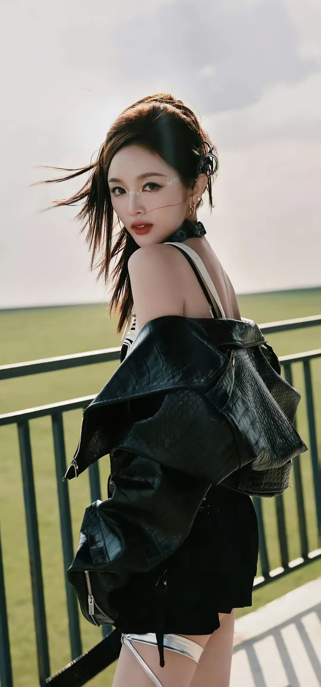 吴宣仪—阳光下的时尚少女，黑色皮夹克与白色连衣裙的完美搭配，尽显个性与优雅。