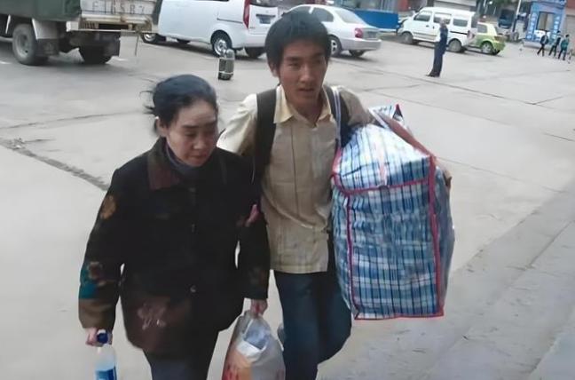 2008年山东临沂，一名22岁来自贵州山区的大一新生，背着患精神病的母亲，跨越2