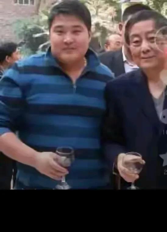 这是宗庆后和大儿子的合照，俩父子长相真的太像了，五官很相似。父子紧挨在一起，亲
