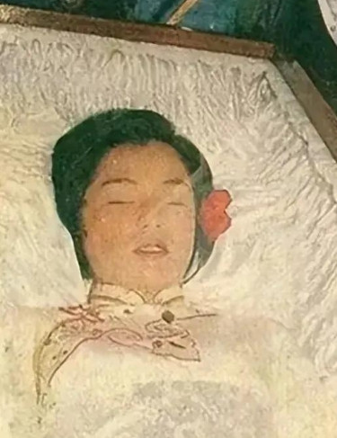 1985年，香港，翁美玲的“大殓”现场，镜头中她的遗体安祥地躺于棺木中，所穿的寿