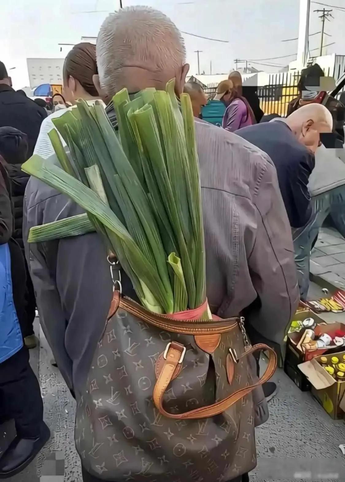 最近网上有张照片挺火——东北早市上，一个大爷把刚买的大葱随手塞进了LV手提袋。画
