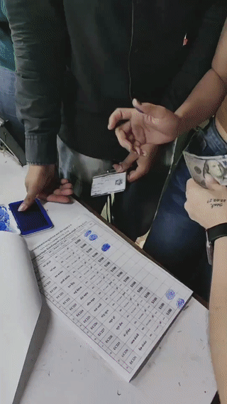 柬埔寨一家中资服装厂里。中国老板正在给当地的工人发放节日奖金。工人们排着队依