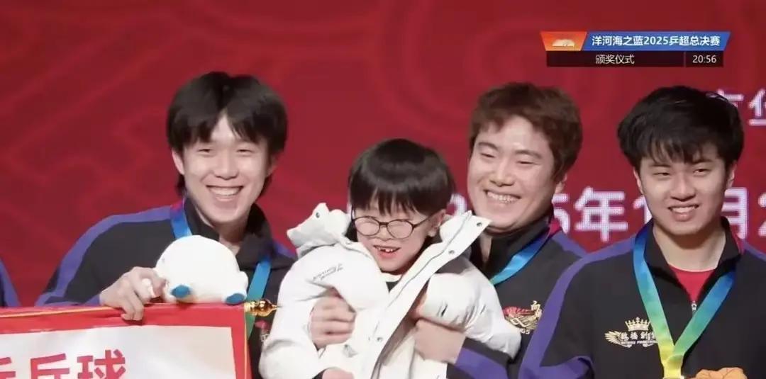 王楚钦抱娃姿势火上热搜梁靖崑把冠军奖杯往地上一放，两岁半的凉皮直接爬上去啃