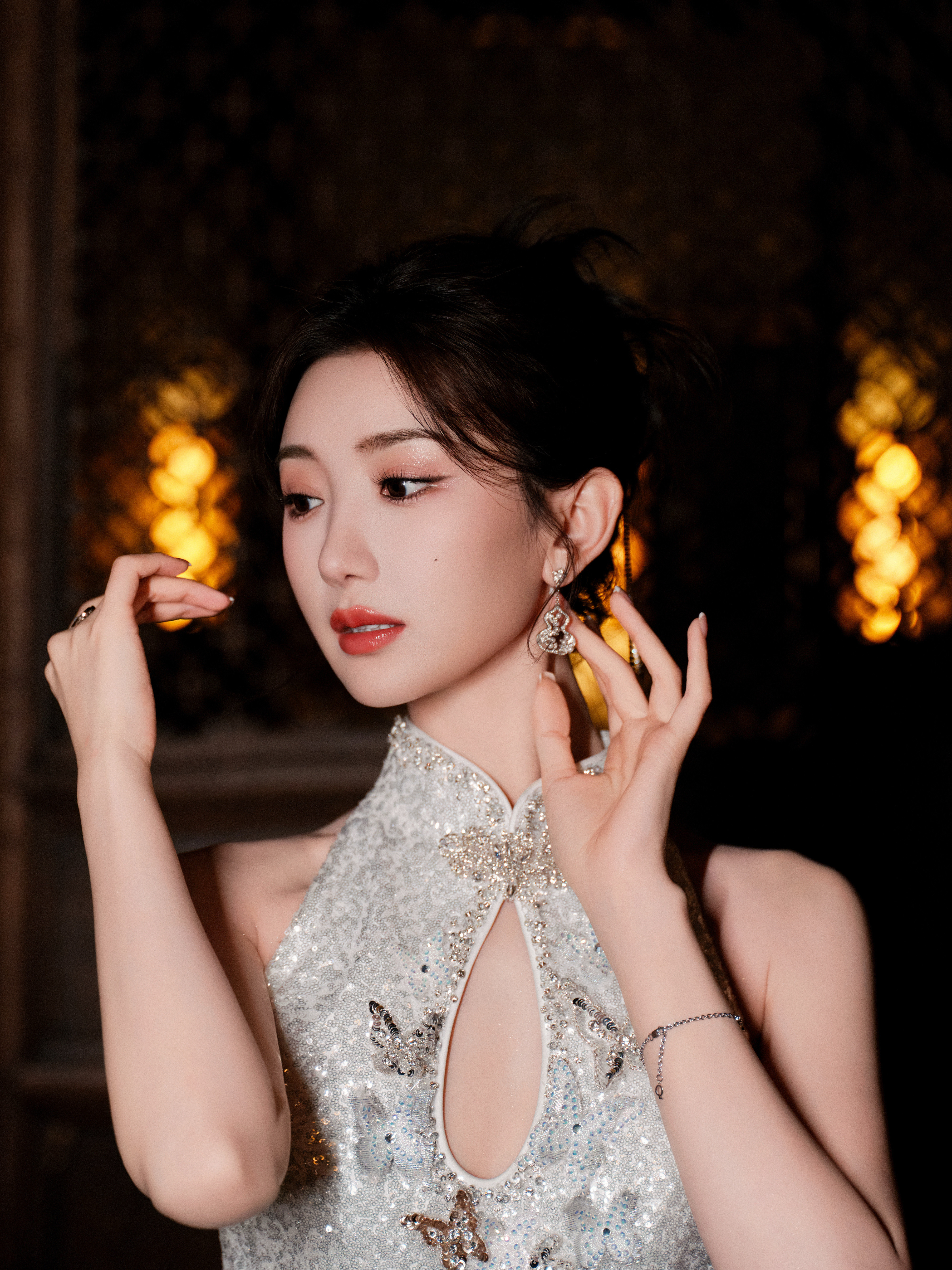 毛晓彤银白亮片旗袍精致剪裁勾勒曼妙身姿，蝴蝶刺绣灵动如生。手持纸伞，眸光流