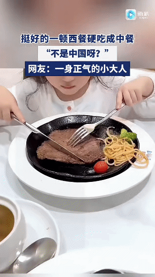 在餐厅里，一份西餐摆在桌上。孩子尝试用刀叉切牛排，觉得“太费劲了”。随后，孩子直