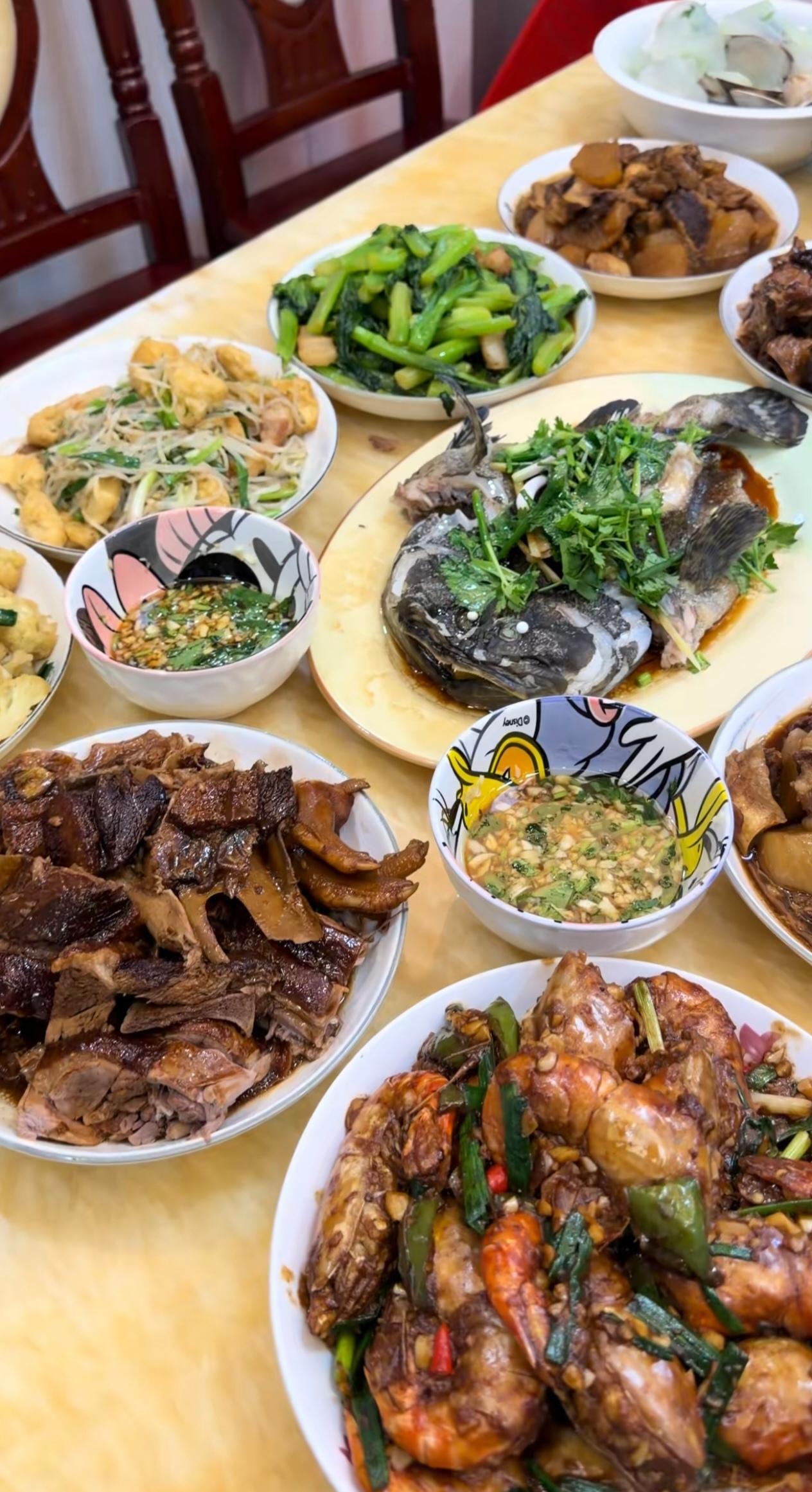受邀去朋友家做客，进门瞬间被满桌菜肴震撼。清蒸石斑、烧鹅、大小双味大虾、炖
