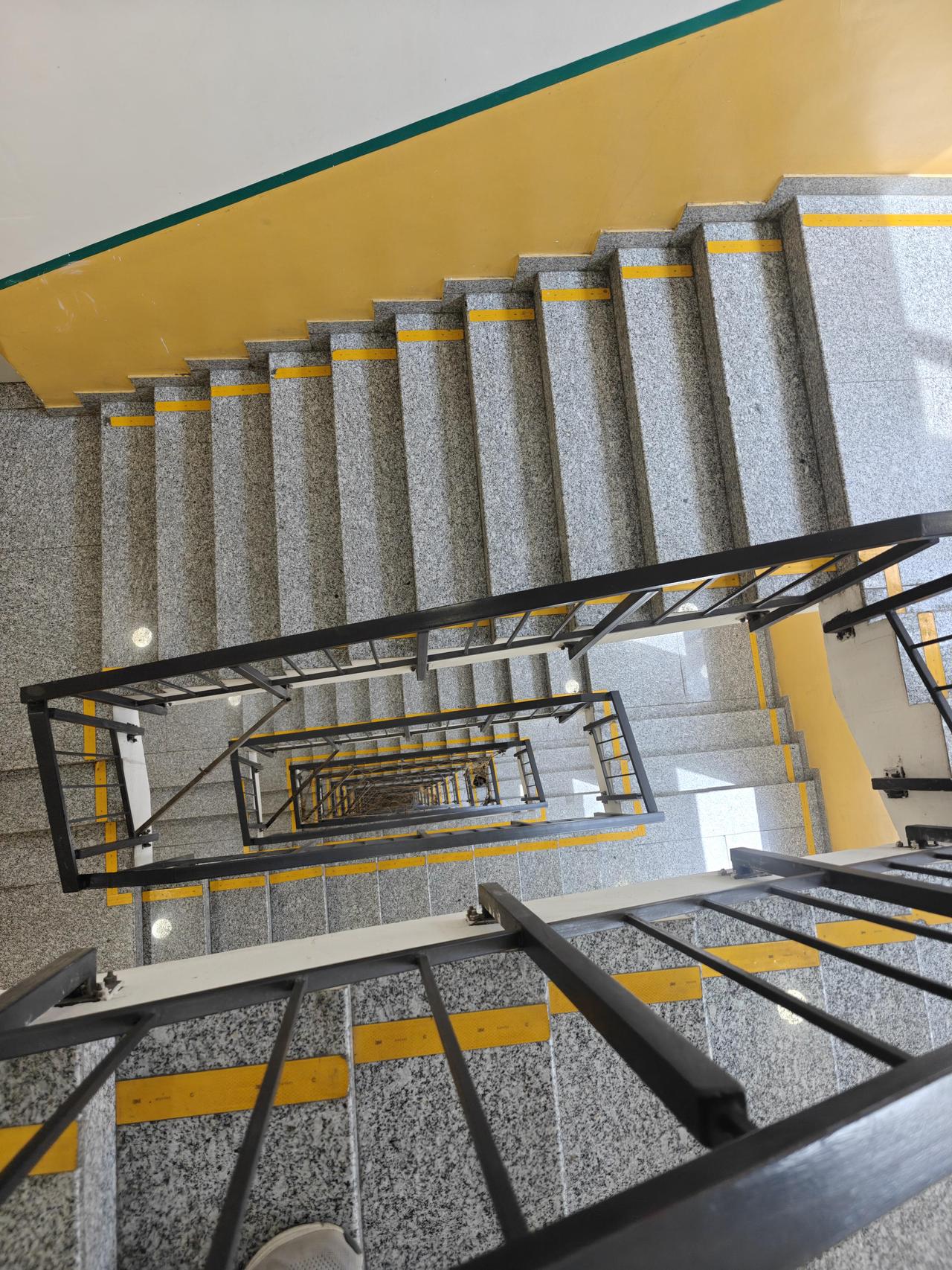 这是某网友办公室的楼梯，中间有个垂直空隙，看起来能直接滑到楼底。每三层都装了塑料