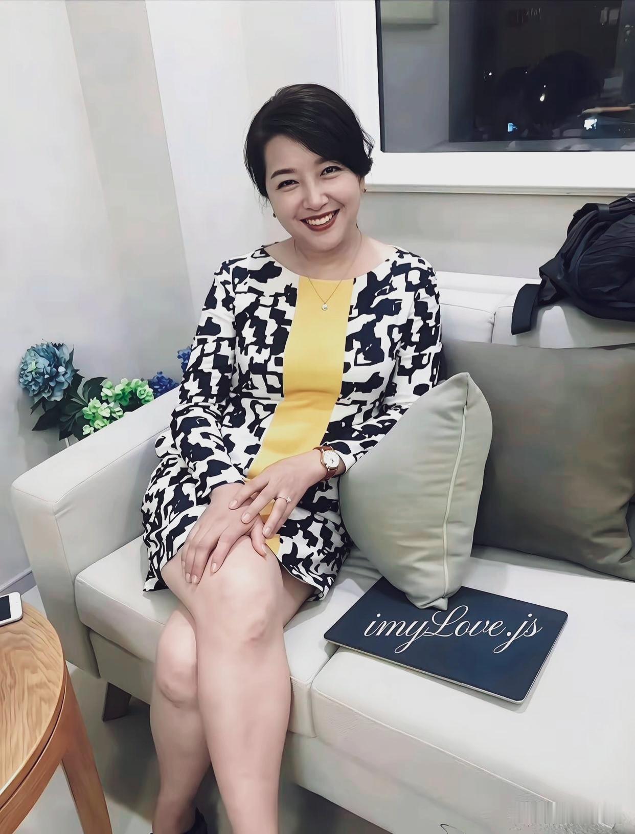 江珊笑容灿烂舒展，坐姿优雅，身材丰腴，浑身散发成熟女性的魅力。