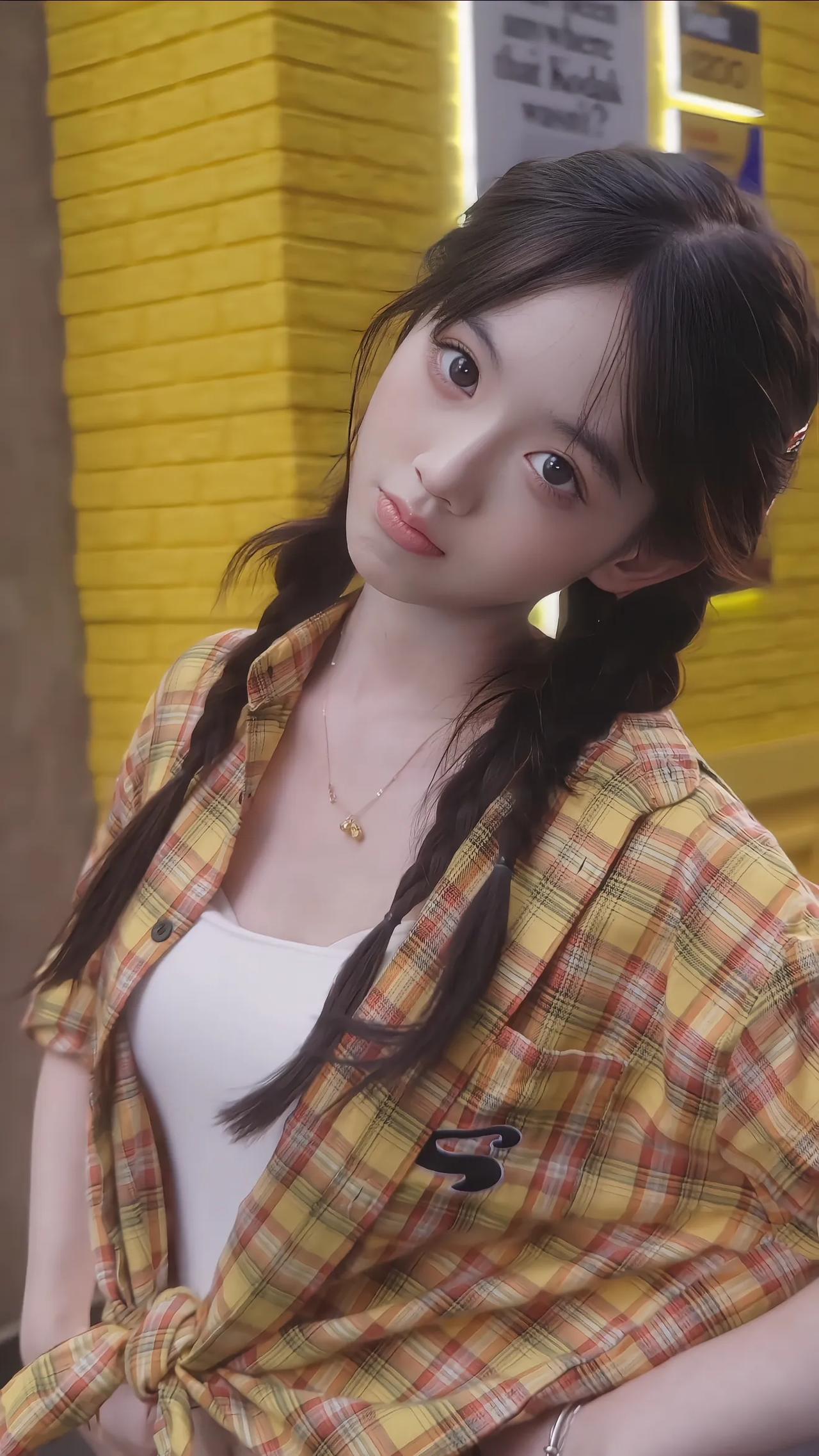 黄衣少女倚墙立，风姿绰约似画中。