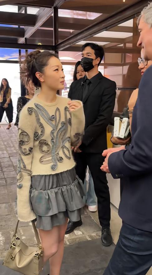 周冬雨这仪态也太随意了吧！周冬雨国外参加时装周，她穿着浅色毛衣搭配短裙，盘发造型