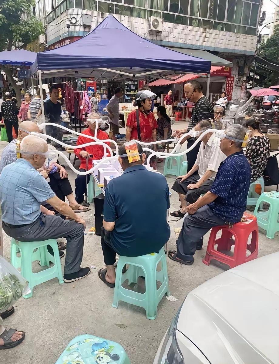 这是什么情况？整条街上坐满老人，路边支着帐篷摆上仪器，好多老人戴着装置坐在那，