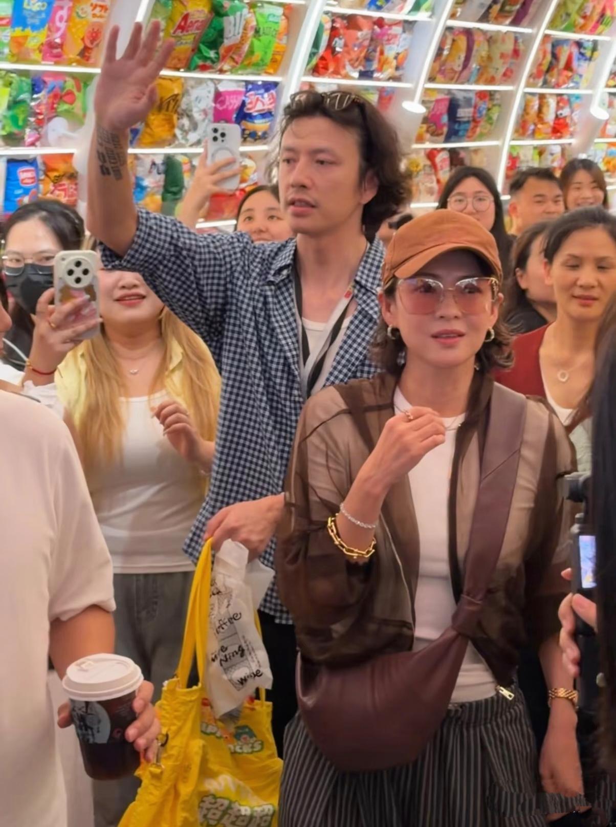 章子怡现身湖南一家零食店，身后一高大蓝色格子衫男子紧紧跟随左右。章子