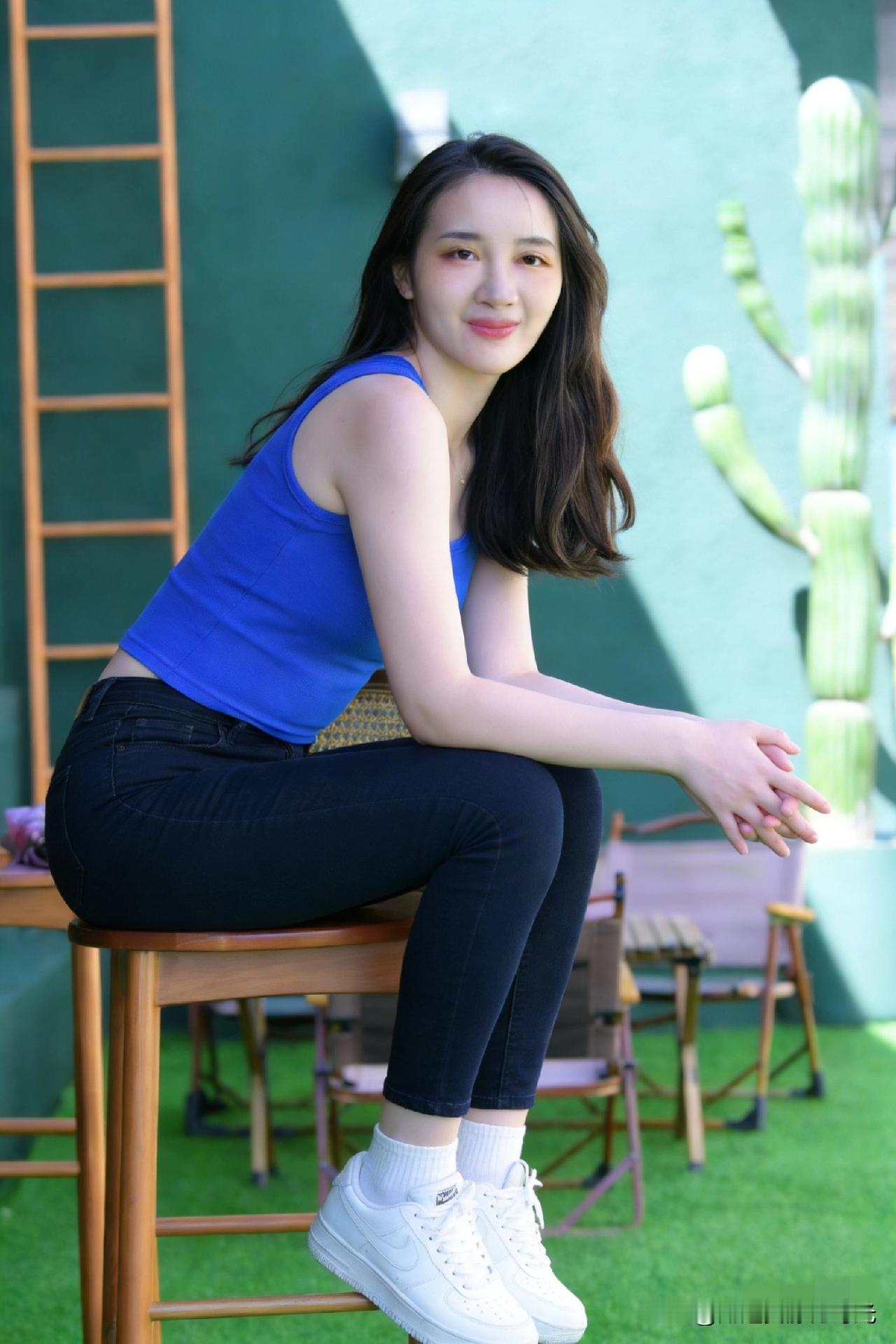 阳光明媚的午后，少女在绿植旁微笑，清新自然。