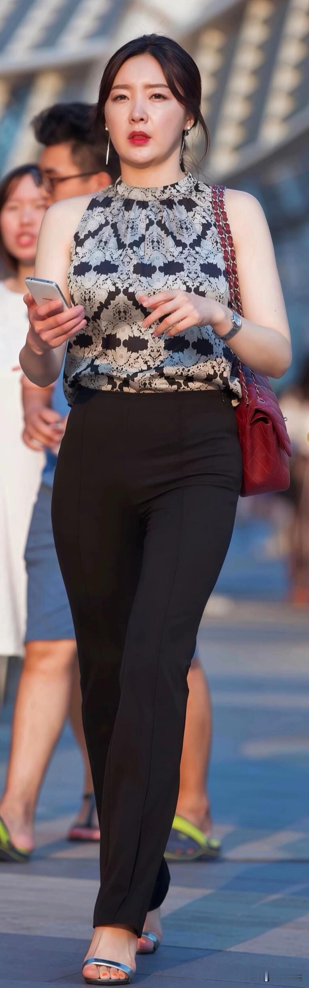 黑白花纹无袖衫搭配高腰黑裤，简约又干练，酒红色菱格包和银色凉鞋点缀，走路带风的都