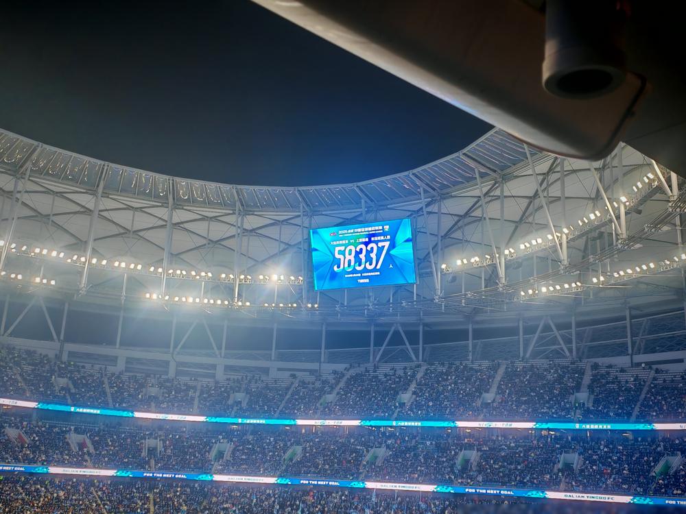 大连英博在梭鱼湾硬刚卫冕冠军，现场涌进六万多球迷，比赛前预估的还多。这场地本来就