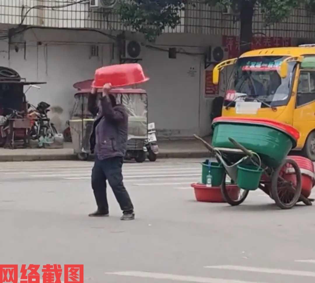 湖北襄阳有大叔在街头推车卖盆。这里大叔停车后拿出自己的塑料盆，为了证明自己盆