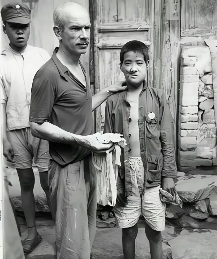 1939年，白求恩给面部中弹的小八路拆线。随军的摄影师沙飞，拍下了白求恩拆线的