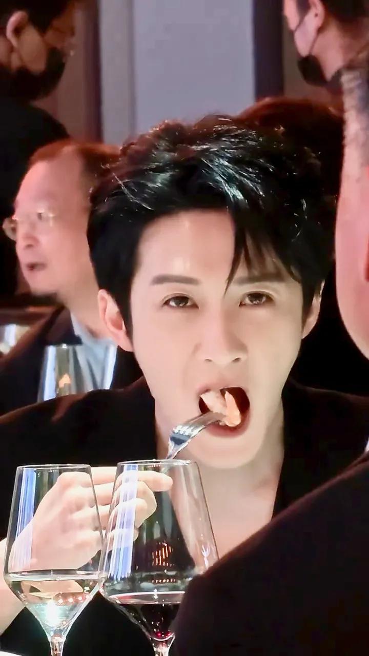 大口吃肉、大杯喝酒，还不忘向镜头、向朋友点头、举杯，这样的檀健次就如婚宴上的宾客