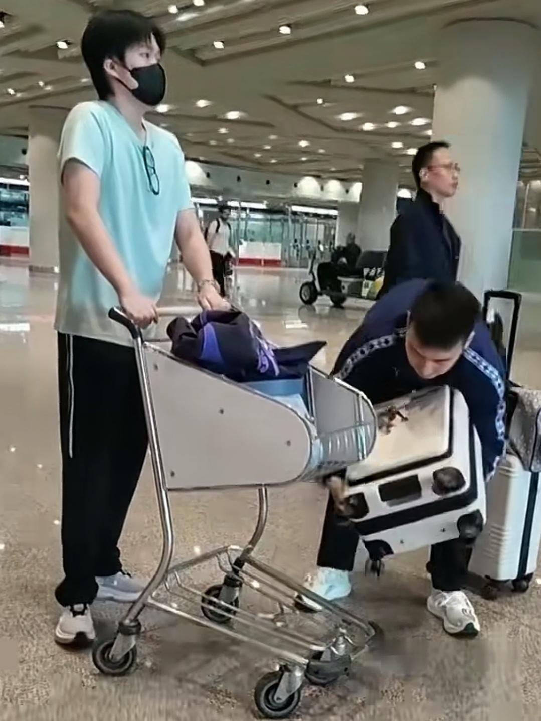 楚钦找来了推车，牛牛弯腰蹲下随手把楚钦的箱子放到车上，楚钦和牛牛继续在机场里前行