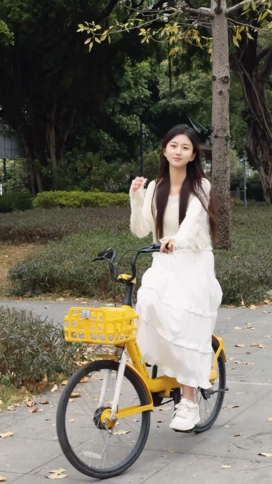 绿树荫中骑车行，白衣飘飘似仙踪。