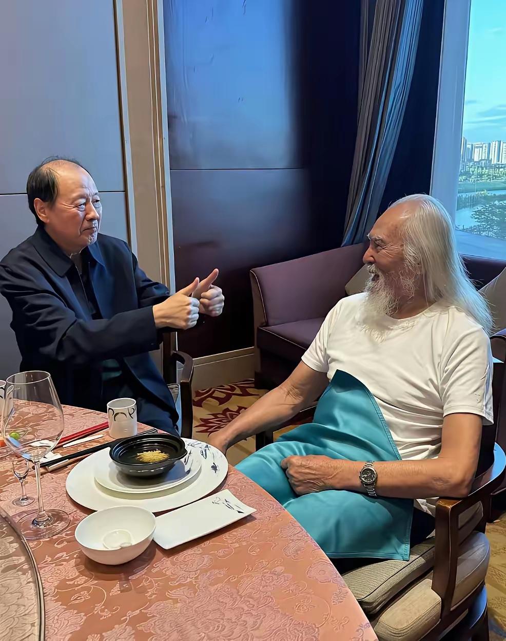 画面中的侯天来略显清瘦，眉淡发稀，目光沉和，点赞的双手保养的白皙平滑；一旁穿着白