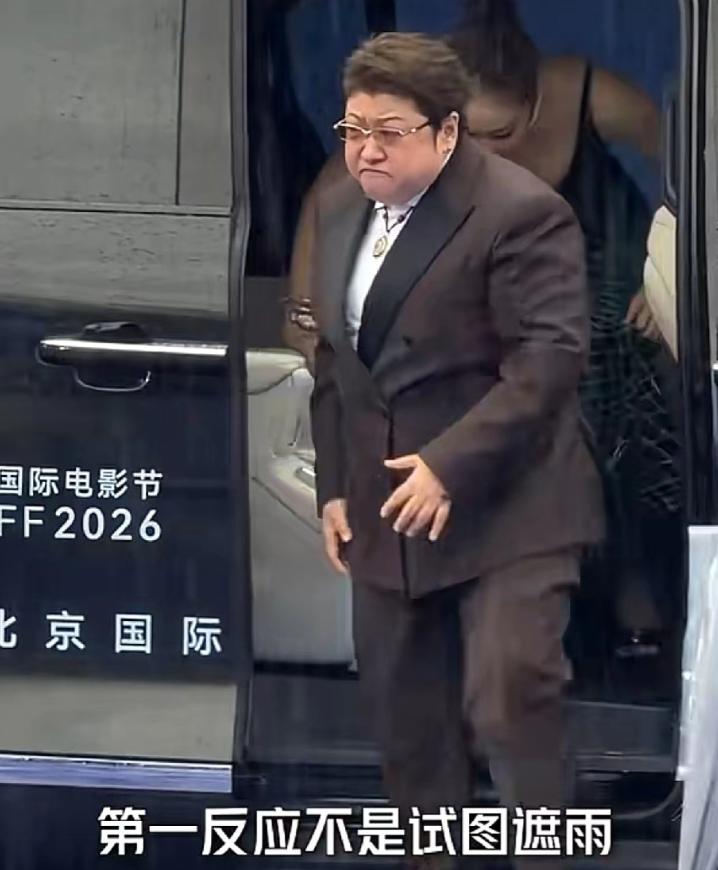 韩红和高叶一同出席北京国际电影节，现场下着瓢泼大雨，韩红下车后紧皱眉头，立刻转身