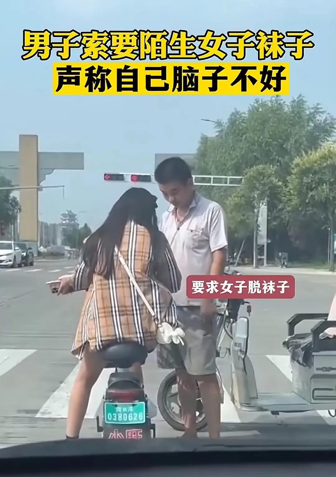 一男子在红绿灯前，趁着车辆等红绿灯之际向一陌生女子索要袜子，并声称自己脑子不好使