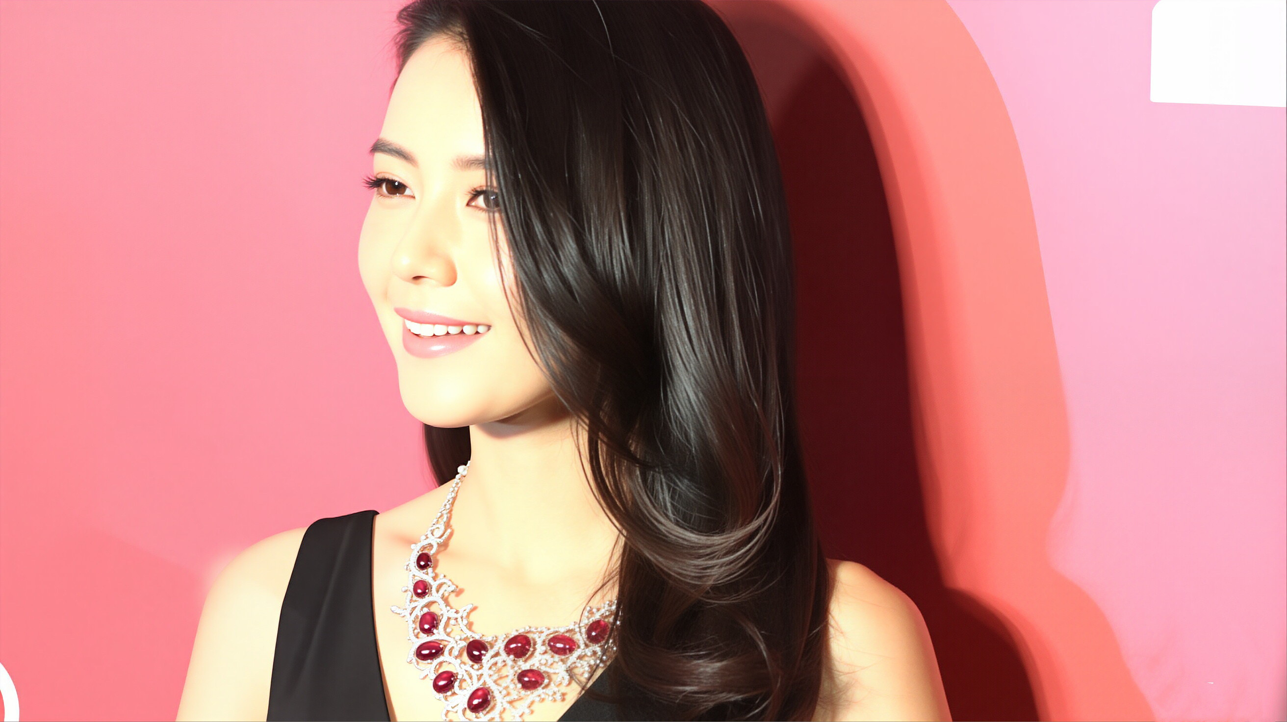 高圆圆一袭黑裙衬得气质温婉大气，红宝石项链在暖光下熠熠生辉，长发柔润地垂落，眉