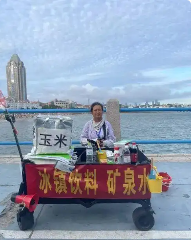 跳海救人的“玉米阿姨”找到了！她叫刘玉荣，摆摊卖玉米收入微薄，被救的女大学生拿着