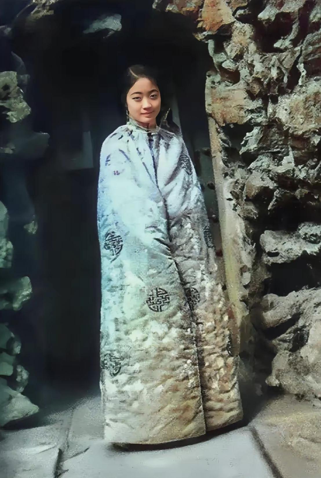 谁能想到，这笑眼盈盈的姑娘竟是末代皇后婉容！裹着绣满寿纹的棉斗篷，蓝料子蹭