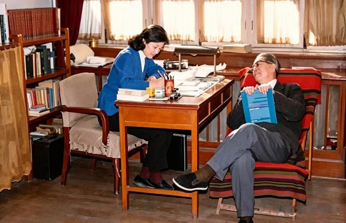 1974年，外交家乔冠华斜倚在椅子上，看着伏案工作的妻子章含之微笑。一个在写，