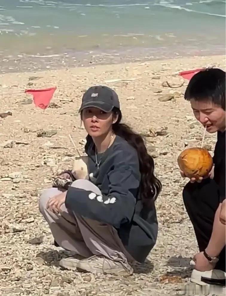 郭碧婷在三亚录节目，抱着椰子在沙滩上捡石头，她黑成焦糖色也也挺美……郭碧婷近期的