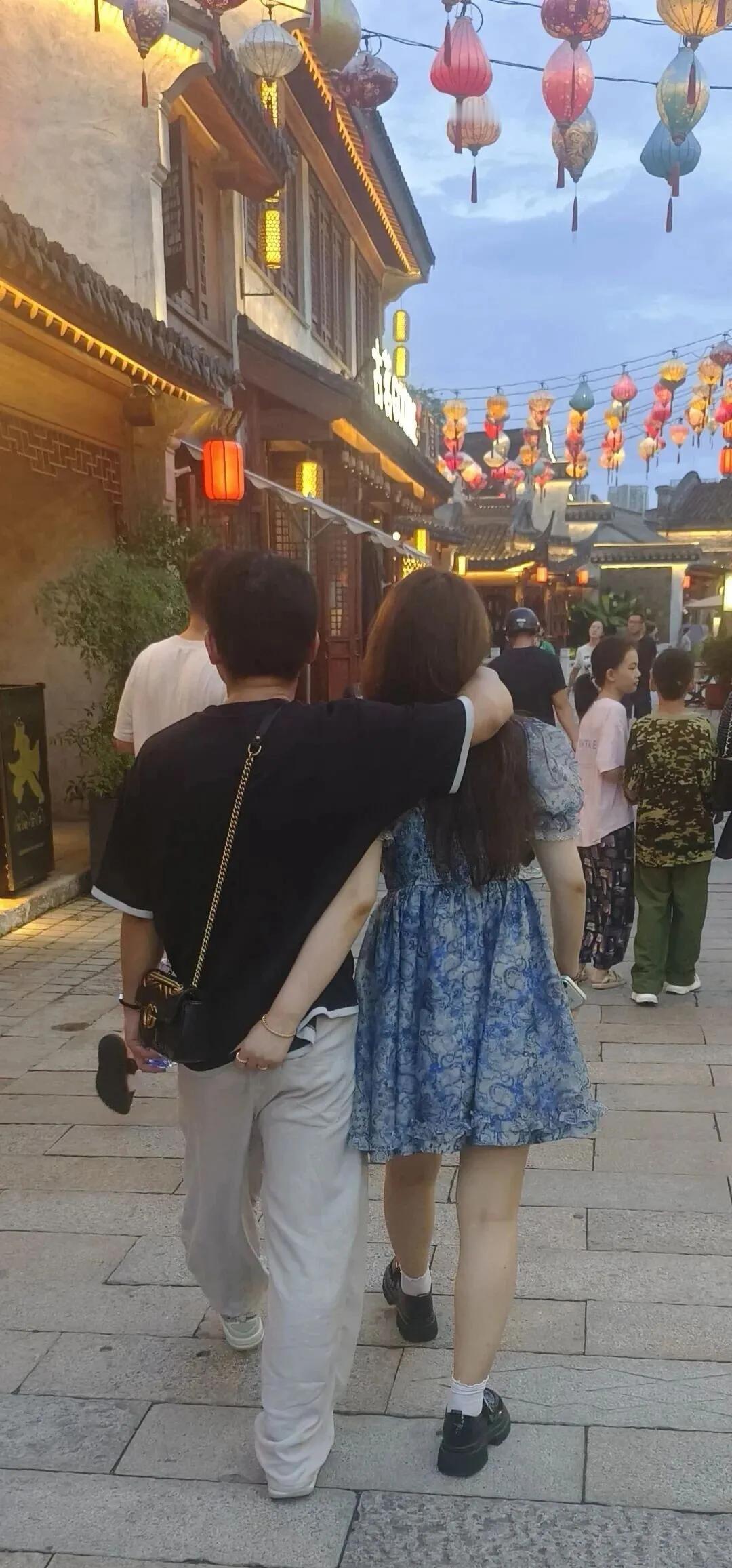 女孩的手在干嘛呢？！傍晚的古镇上，一对热恋中的暑假中的大学生，相依相偎走在古街