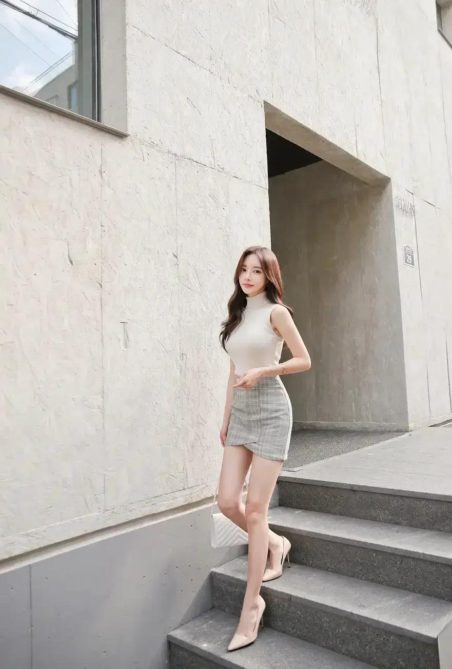 站在楼梯上，穿着时尚又优雅。