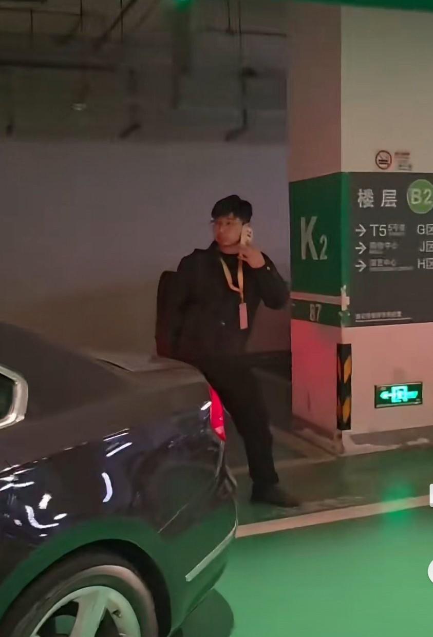 在上海的一商场停车场内，一戴着“2025进博会参展商”工牌的男子人肉占车位，没素