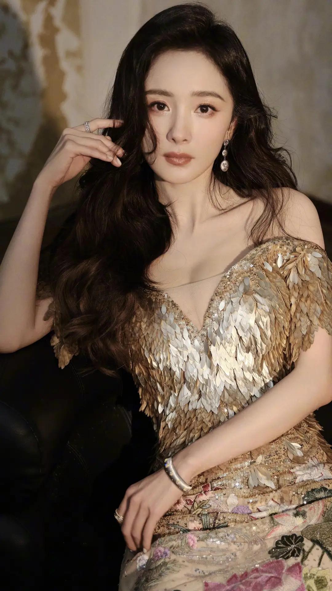 杨幂一袭金鳞露肩礼服，将贵气与柔美揉进每一寸细节。亮片如羽翼缀满裙身，在光影间流