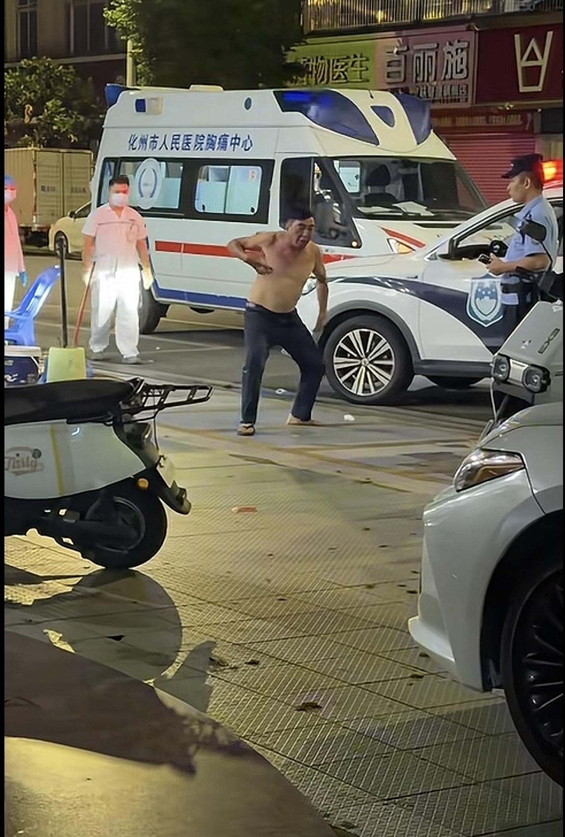 这位大哥喝多了酒，光着上衣就在街上耍酒疯，从视频可以看到警方和救护车都来了，不过