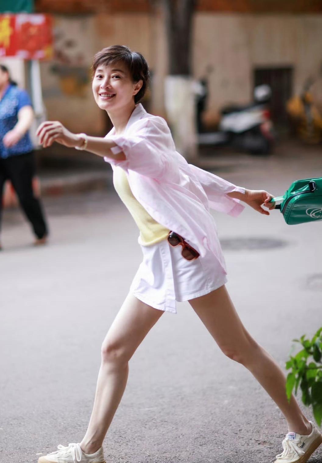 吴越分享了自己的美搭，穿粉色衬衫+超短款白色半身裙，内搭黄色打底衫，脚踩小白鞋，