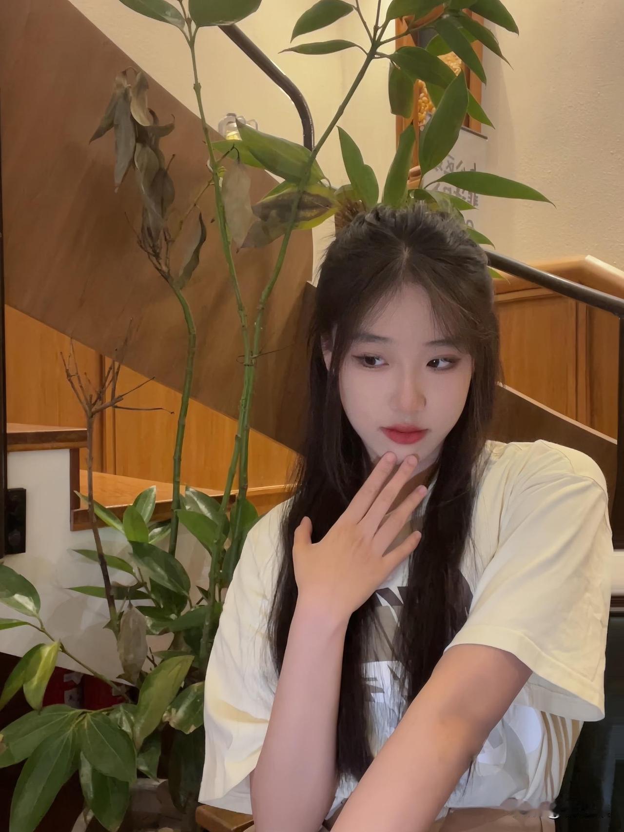 绿植掩映中，佳人轻抚面。