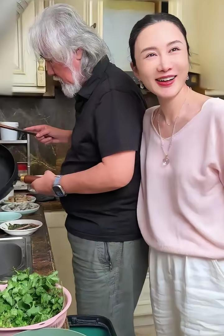 刷到一张图时愣了愣——白发大叔张纪中在灶台前颠勺，旁边站着位黑发女士杜星霖笑得眼