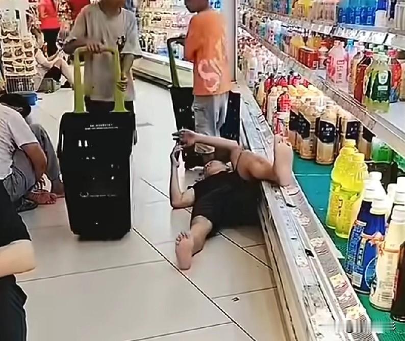 几个男人光着脚在坐在超市地上蹭空调，看这场景，让不让人恶心。其中一个男人