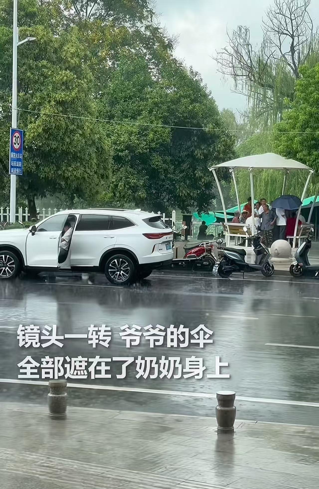 “火到人民日报！”暴雨突下，一个老爷爷推着老伴淋雨行走。这时，一个男子开车路上，