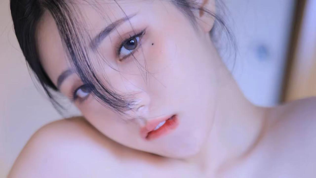 想象中，那个沉思的少女置身于静谧的白色空间。她一头黑发如瀑布般垂落，在安静的氛围