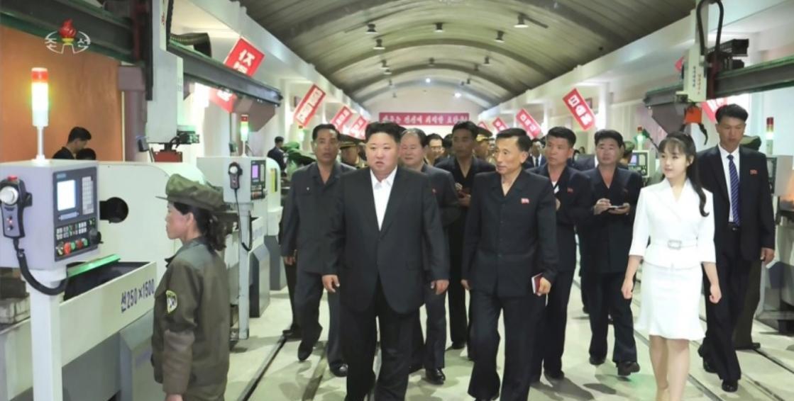 朝鲜电视台报道了金正恩近日视察朝鲜重要的军需工业企业。这张照片里左侧是一名工厂女
