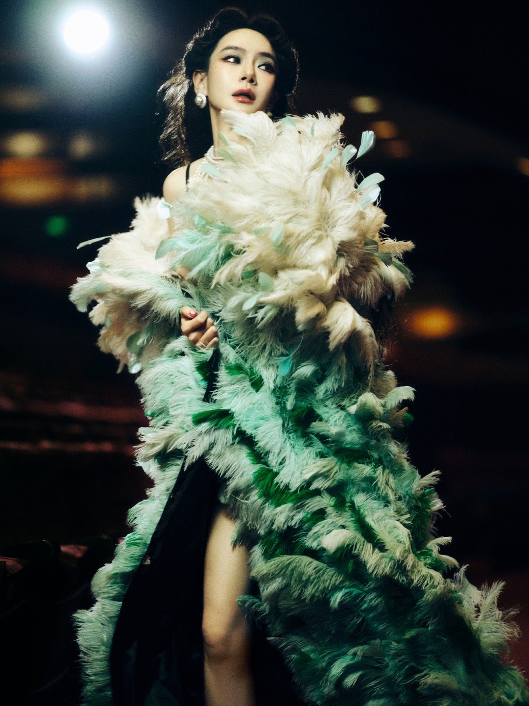 戚薇珍珠项链叠戴羽毛披风是梦境，黑色吊带是现实，而叠戴的珍珠项链，是戚薇连接两