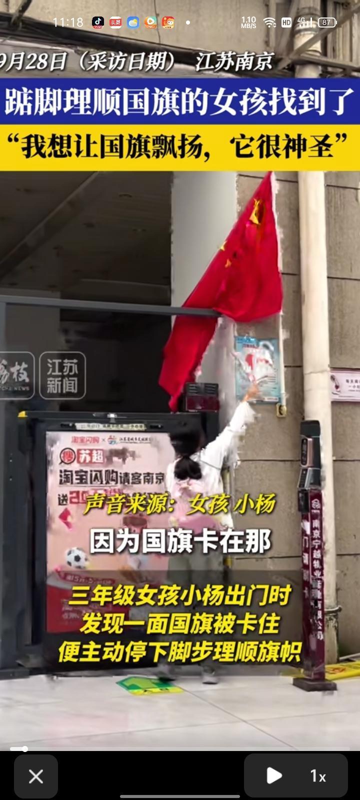 9月28日，江苏南京。三年级女孩看见国旗卡在栏杆里，就想办法去够到它。先是用伞，