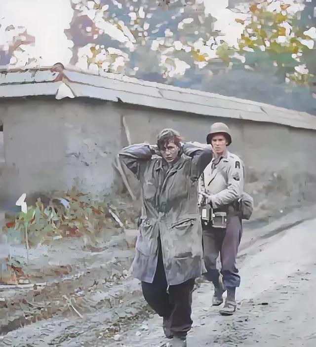 1945年，美军士兵正在押解德军女战俘。这名女兵身高足有1米75，留着利