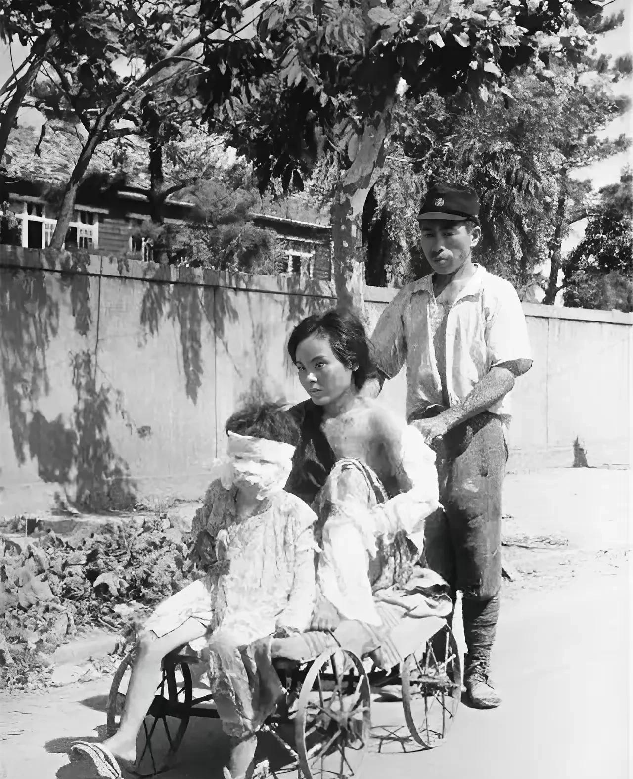 这是1945年在广岛街头，一名日本兵推着四轮车，上面坐着自己的妻儿，在原子弹爆炸