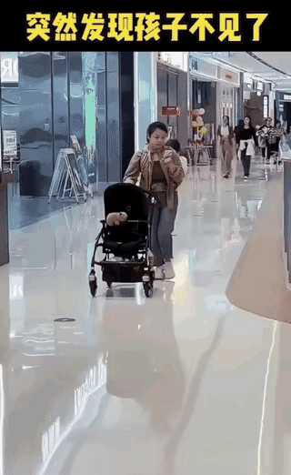 大搞笑了背着娃儿找娃儿超市里年轻的妈妈一手看着手机一手推着婴儿车突